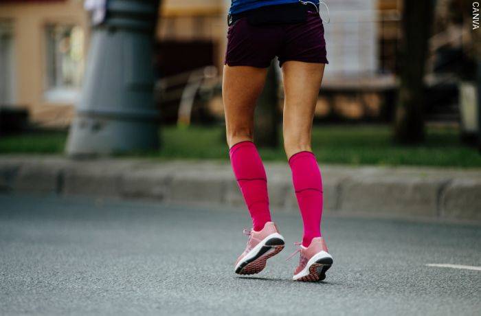Foto de una mujer corriendo con medias de compresión