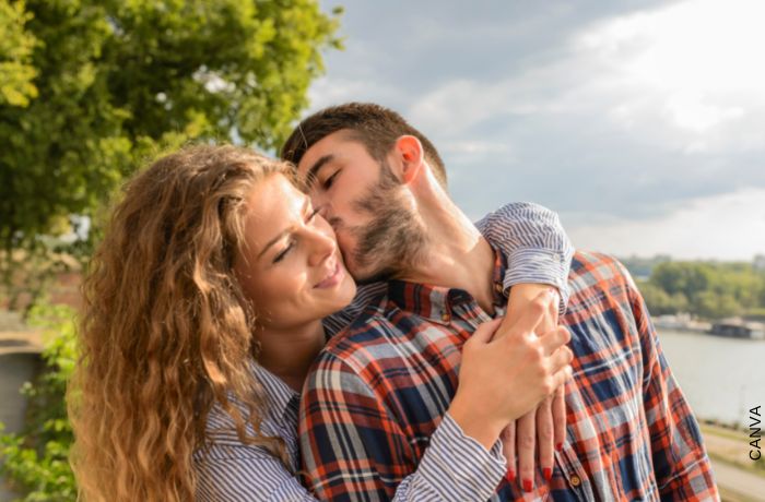Foto de un hombre dándole un beso en la mejilla a su pareja