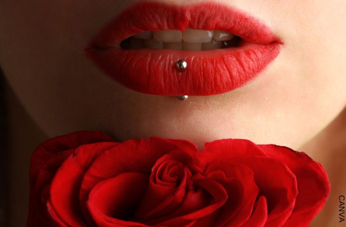 Foto de unos labios rojos con una rosa delante