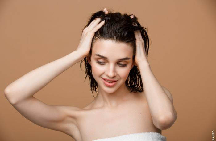 Foto de mujer haciéndose masaje en el cuero cabelludo
