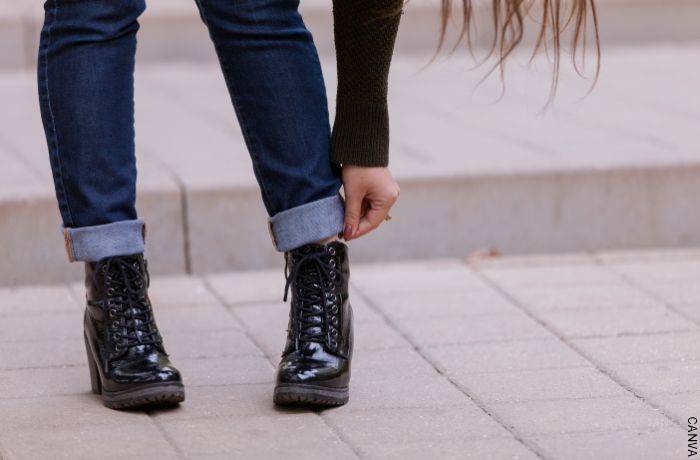 Foto de chica arreglándose la bota de los jeans
