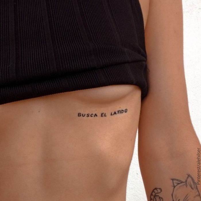 Foto de tatuaje en de frase en el pecho de mujer