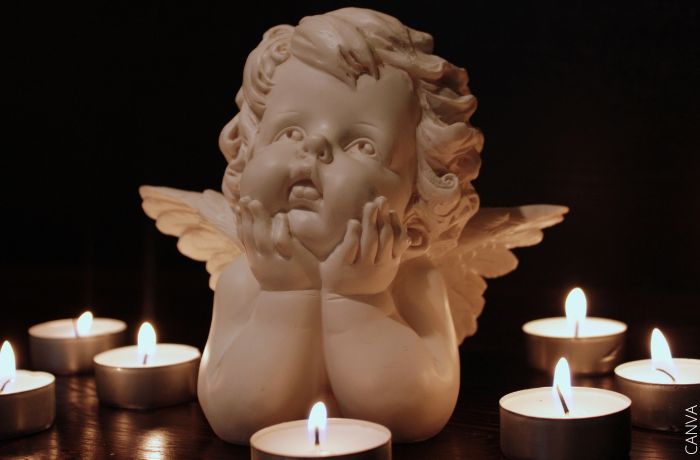 Foto de una figura de un ángel entre velas
