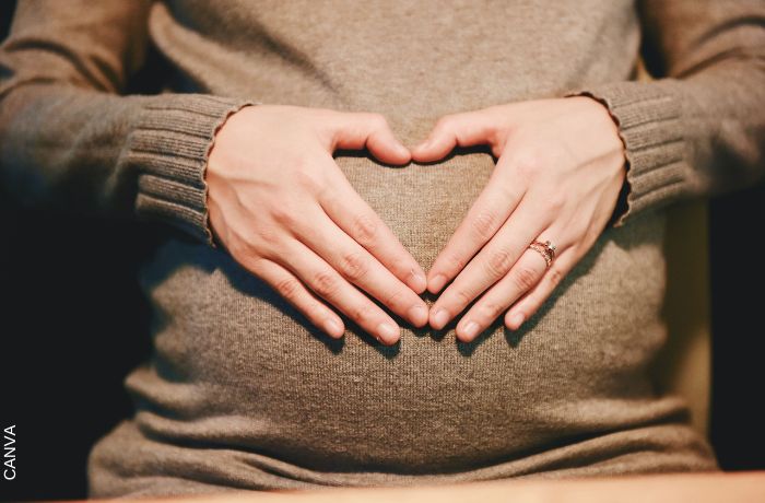 Foto de mujer embarazada haciendo un corazón con las manos