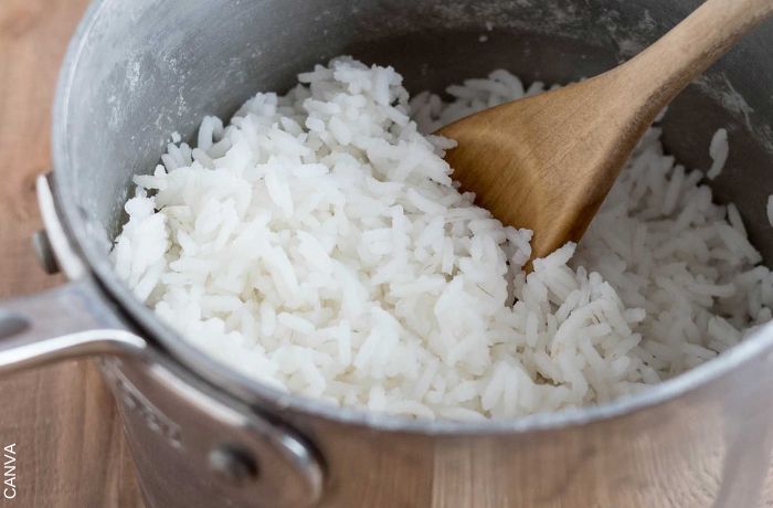 Foto de olla con arroz y una cuchara de palo
