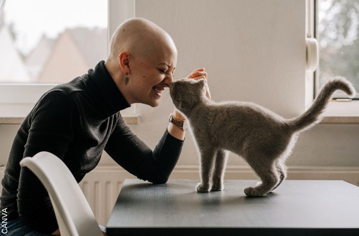 Foto de mujer jugando con su gato