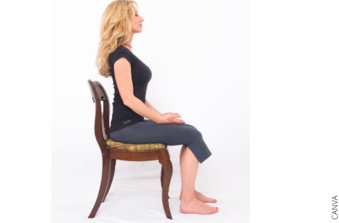 Foto de una mujer meditando sentada en una silla