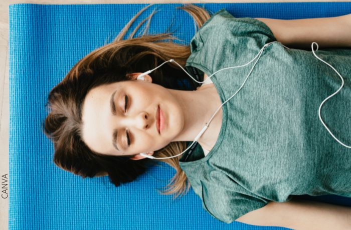 Foto de una mujer acostada con audífonos