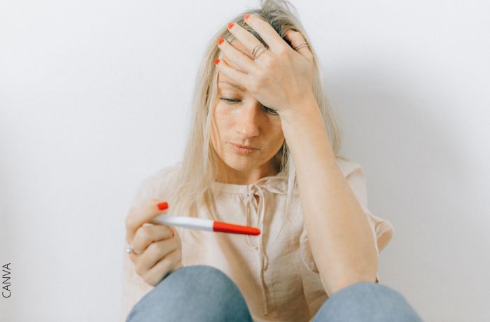Foto de una mujer viendo una prueba de embarazo