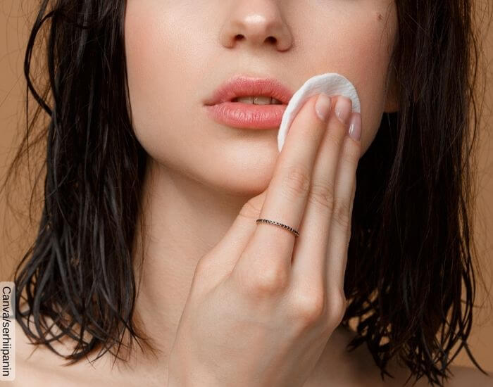Foto de una mujer limpiando la zona del bigote de su rostro con un pomo de algodón