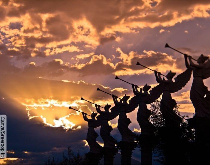 Foto de varias estatuas de ángeles tocando las trompetas del cielo con un atardecer de fondo