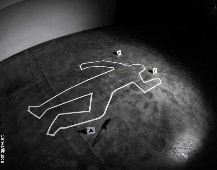 Foto del croquis en cinta blanca de un cuerpo en una escena del crimen junto a un cuchillo