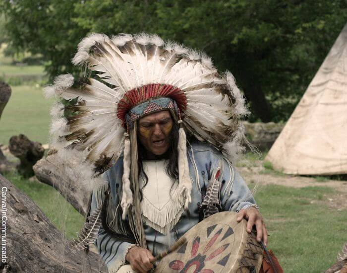 Foto de un indígena con un penacho indio en su cabeza