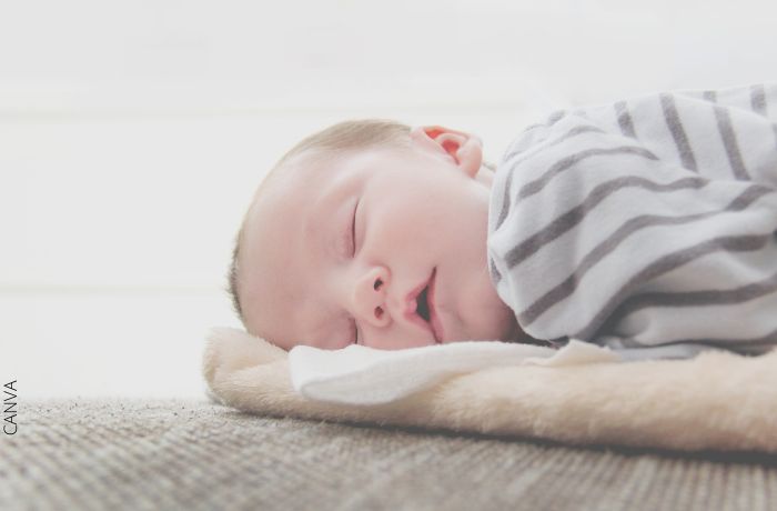 Foto de un bebé durmiendo con pijama de rayas