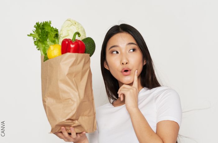 Foto de una mujer con una bolsa de verduras