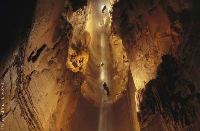 Foto de una cueva con hombres descendiendo