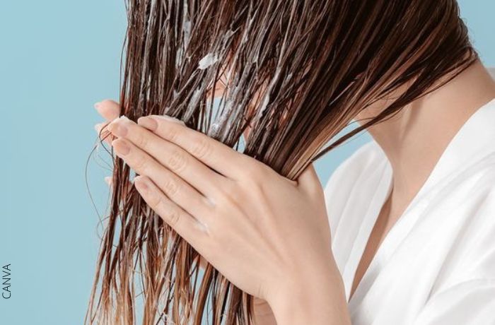 Foto de mujer aplicando mascarilla de aceite de coco para el cabello