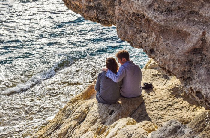 Foto de una pareja sentados cerca del mar