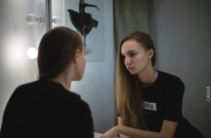 Foto de una mujer mirándose al espejo