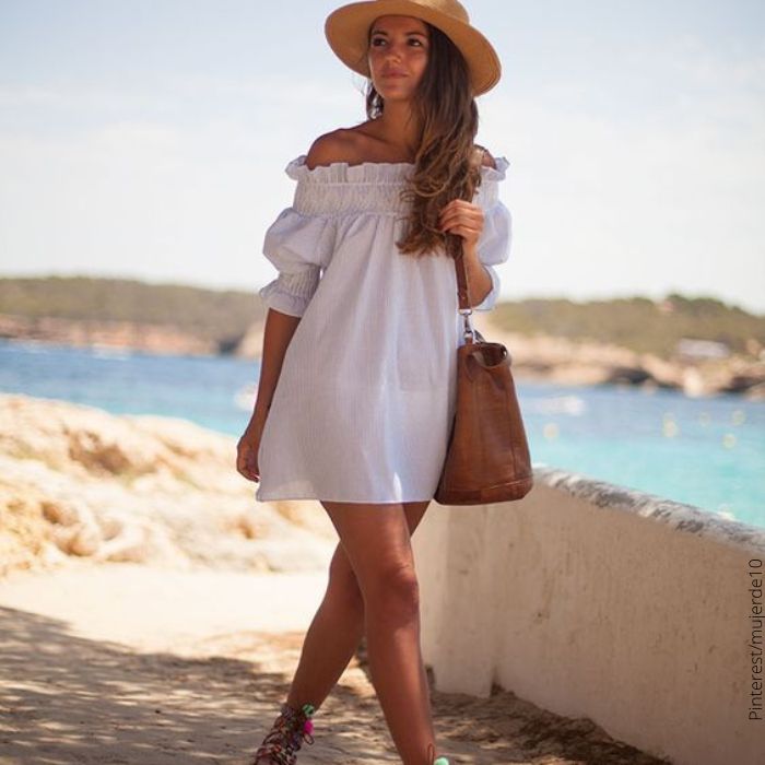 Foto de mujer en la playa con vestido blanco