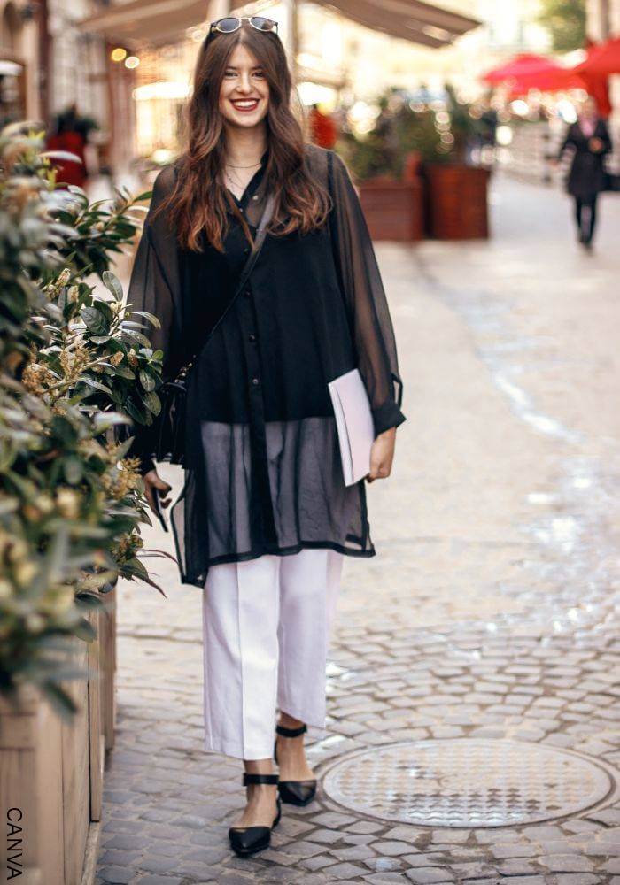 Foto de mujer con blusa negra y pantalón blanco