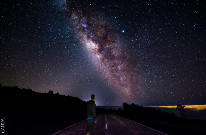 Foto de un hombre mirando al cielo en la noche