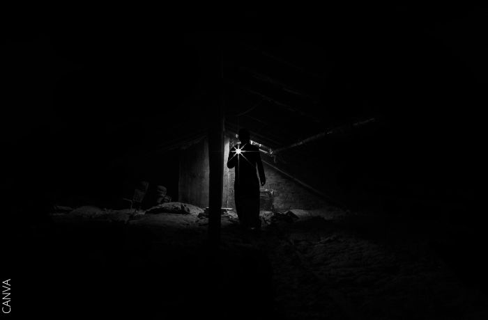 Foto de una persona en la oscuridad con una linterna