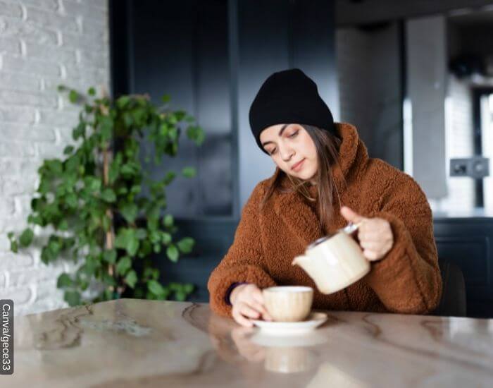 Foto de una mujer agripada tomando té de pronto alivio para curar sus síntomas