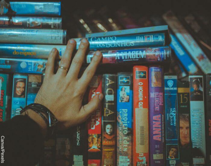 Foto de una colección de películas en formato VHS con una mano sobre ellas