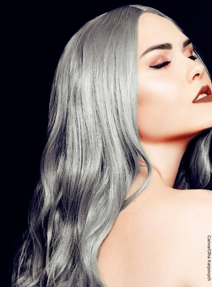 Mujer posando con los ojos cerrados con el pelo decolorado de tonos grises