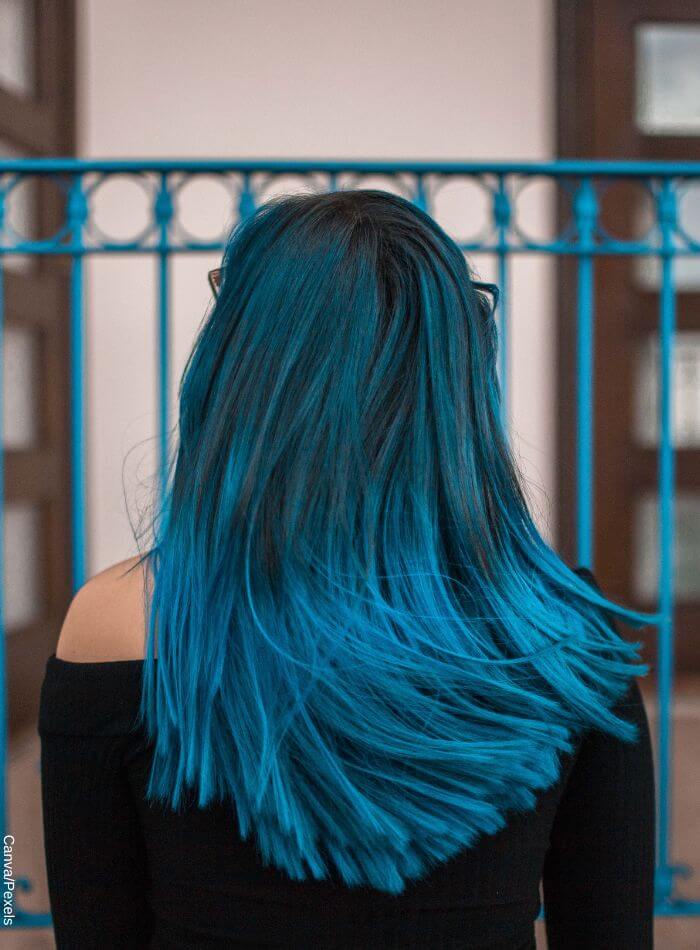 Foto de espaldas de una mujer con pelo negro y balayage azul vibrante