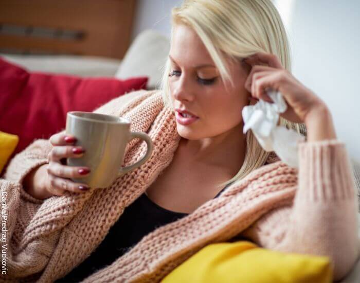 Foto de una mujer agripada tomando té de poleo para la congestión nasal