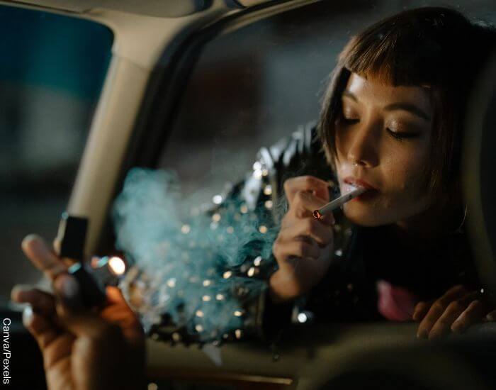 Foto de una mujer prendiendo un cigarrillo