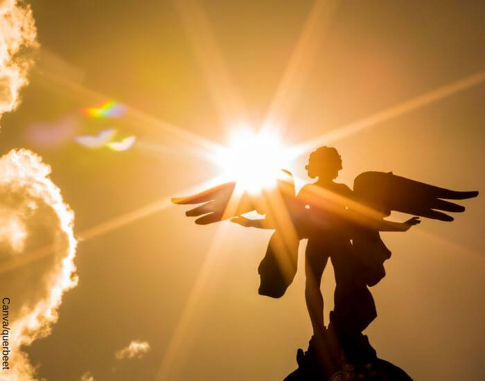 Foto de una estatua de un ángel siendo ilumanda por el rayo del sol