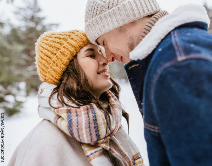 Foto de una pareja afuera en invierno juntando sus frentes y tocando sus narices en representación de lo que es tener química con una persona