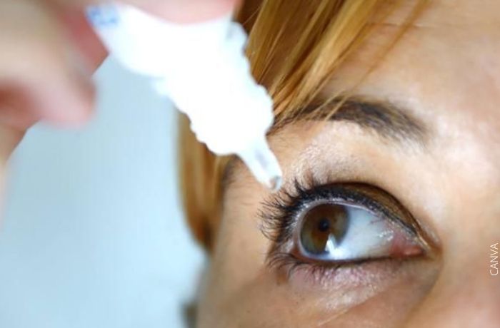 Foto de una mujer aplicándose gotas en los ojos