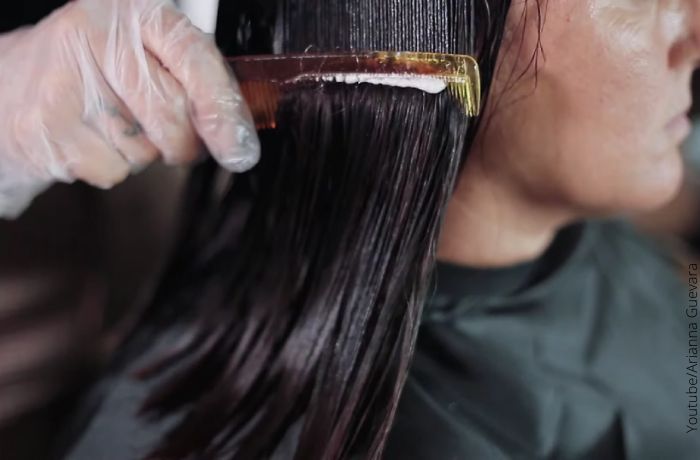 Foto de una mujer peinando un producto en su cabello