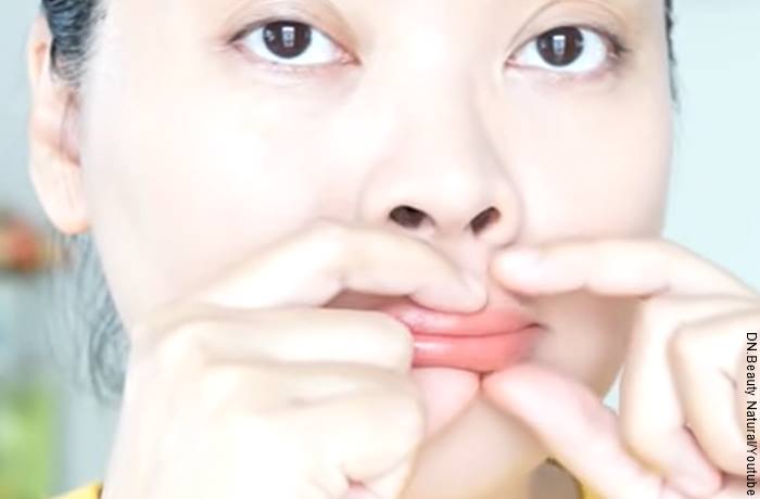 Fofo de una mujer apretándose la boca para ilustrar cómo maquillar los labios para que parezcan más gruesos