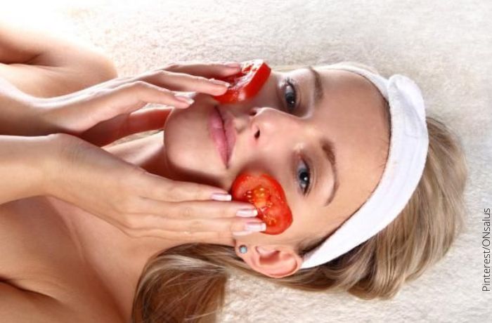 Foto de una mujer con rodajas de tomate en la cara