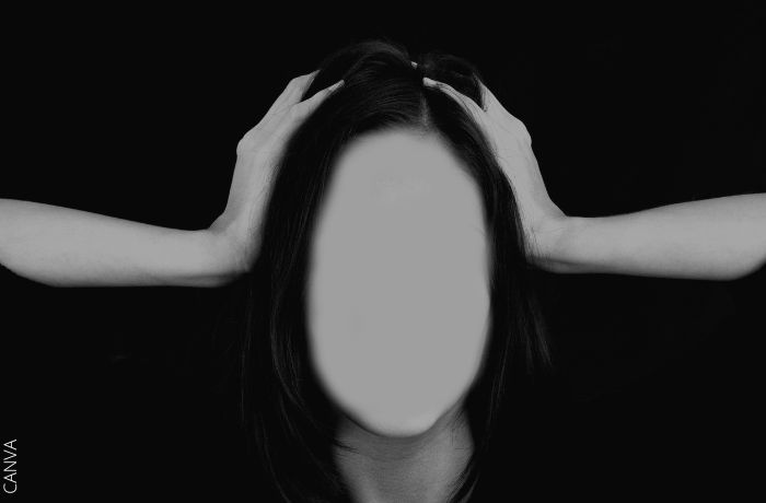 Ilustración a blanco y negro de una mujer con las manos en la cabeza y sin rostro