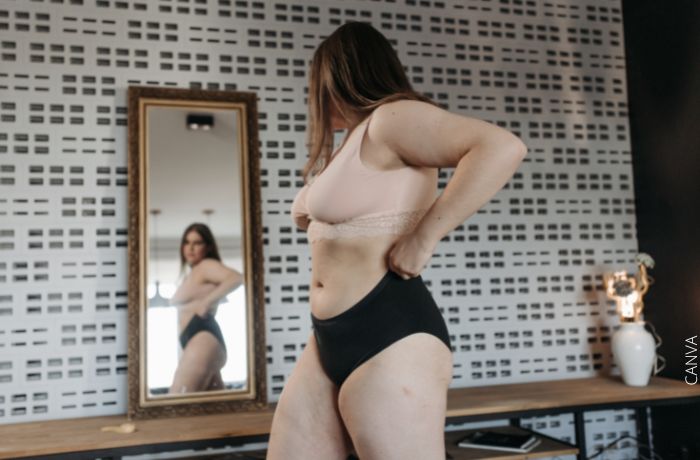 Foto de una mujer mirándose al espejo