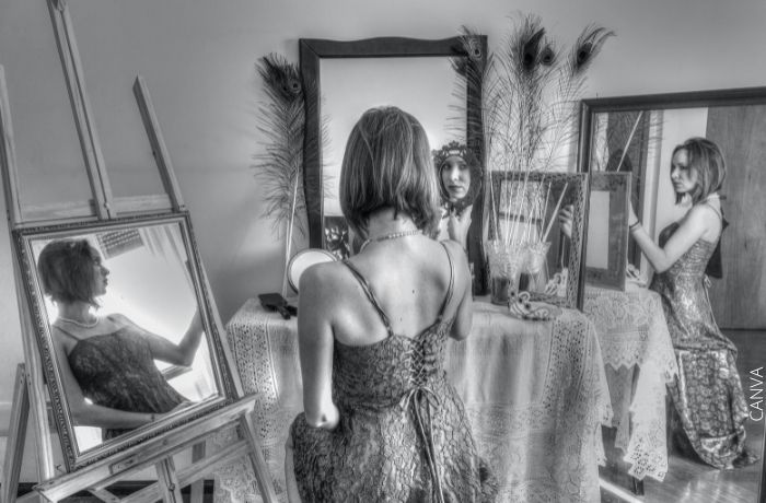 Foto a blanco y negro de una mujer rodeada de espejos