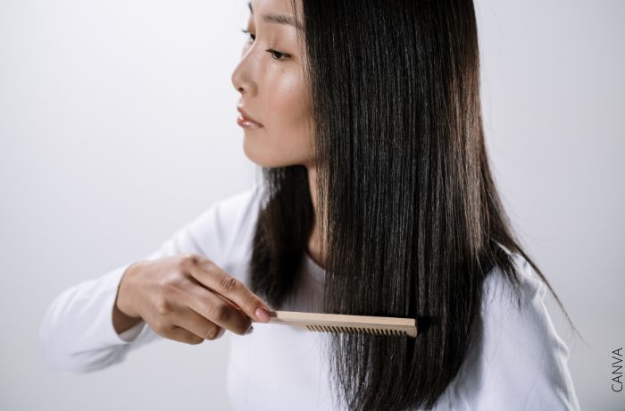 Foto de una mujer con cabello liso pasando un peine