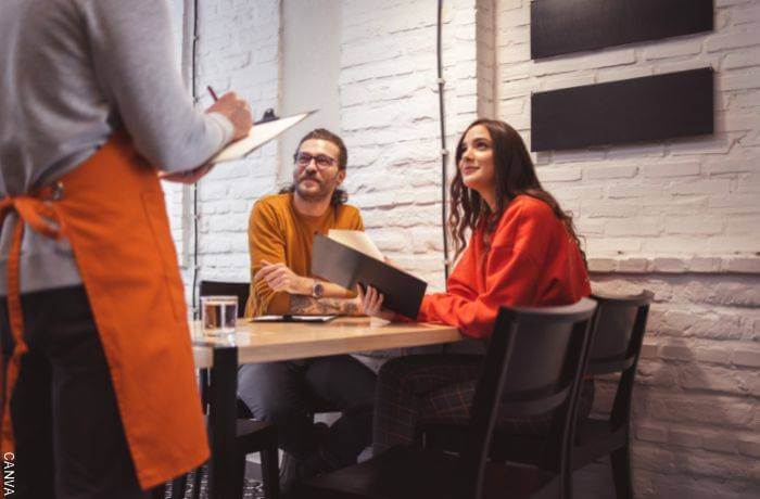 Foto de una pareja haciendo un pedido en un restaurante al mesero