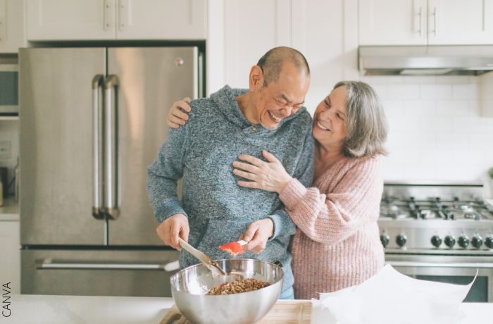 Foto de una pareja riéndo mientras están en la cocina