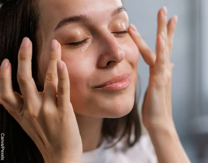 Foto de una mujer humectando su rostro con la yema de sus dedos como parte de su rutina de skincare