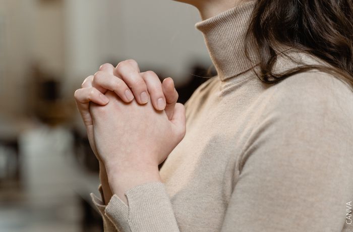 Foto de una mujer con las manos juntas orando