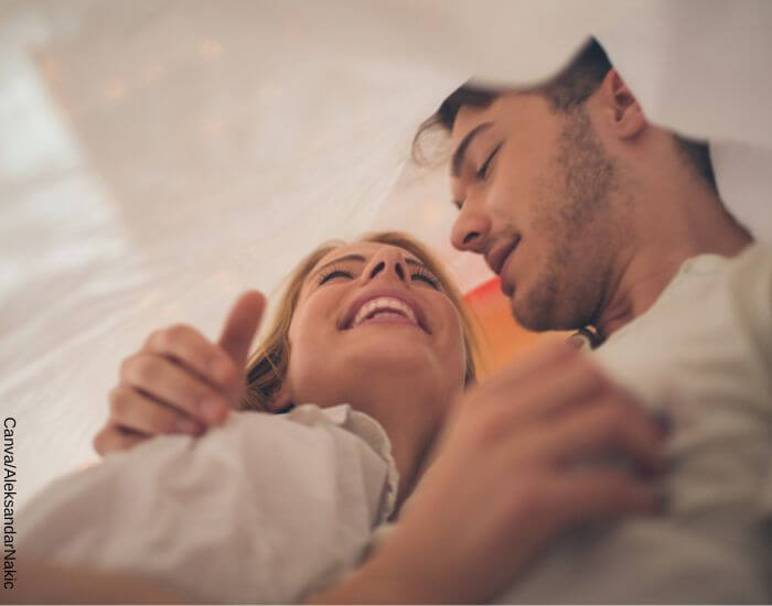 Foto de una pareja abrazada y riendo entre una cortina