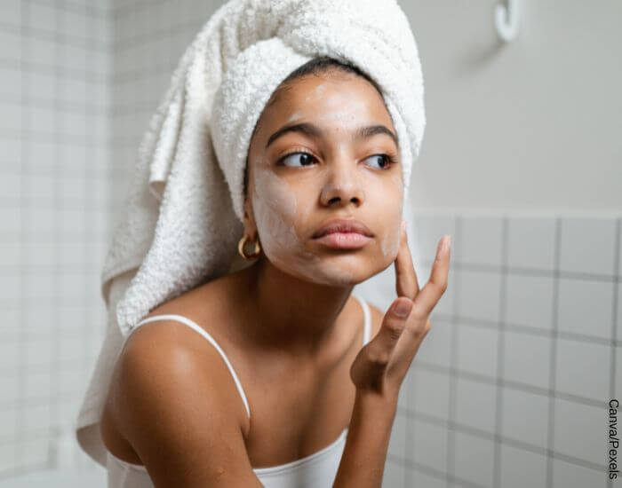 Foto de una mujer recién salida de la ducha aplicándose una mascarilla casera en la cara