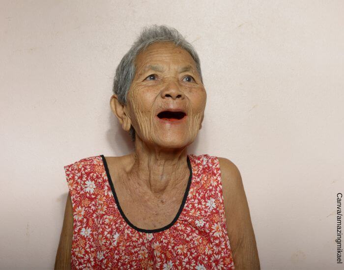Foto de una abuela abriendo la boca y mostrando que no tiene ningún diente